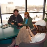 Sinclair students Jesse Cooley, Chloe Bailey and Bob Battigaglia gather around a computer plugged in at Building 13.