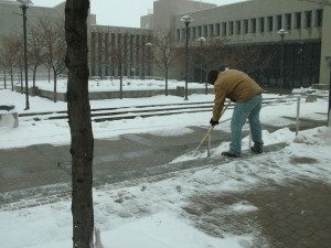 A maintenance worker clears the courtyard steps of snow on Feb. 15 at Sinclair Community College.  The campus announced its third snow day in seven days.